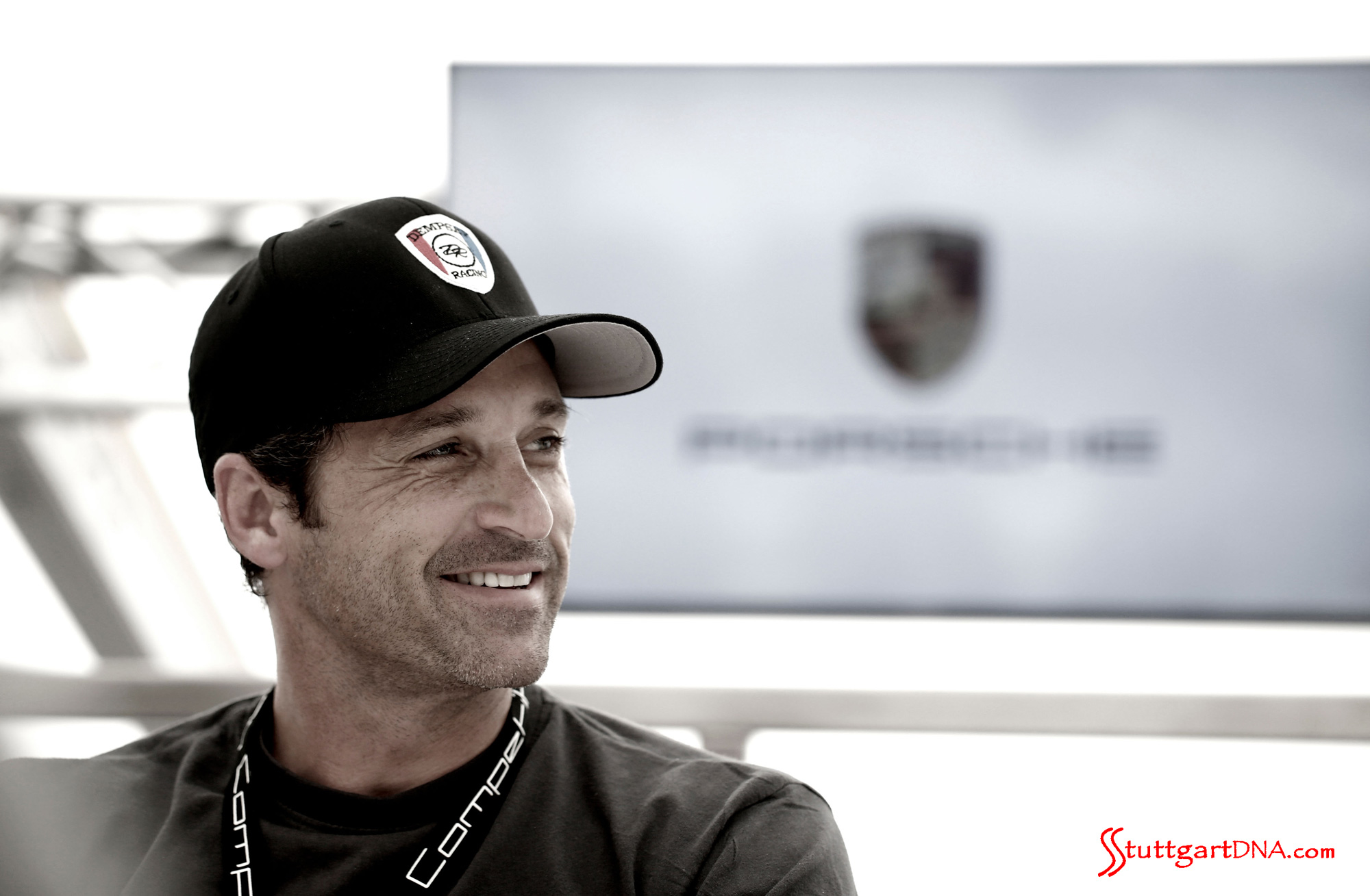 Patrick Dempsey pilots Porsche in 2015 WEC Patrick Dempsey pilots Porsche in 2015 WEC: Patrick Dempsey seen here in a right-side portrait, with Porsche flag in b.g. He signs with Porsche again to contest the 2015 FIA WEC and Le Mans. Source: Porsche AG