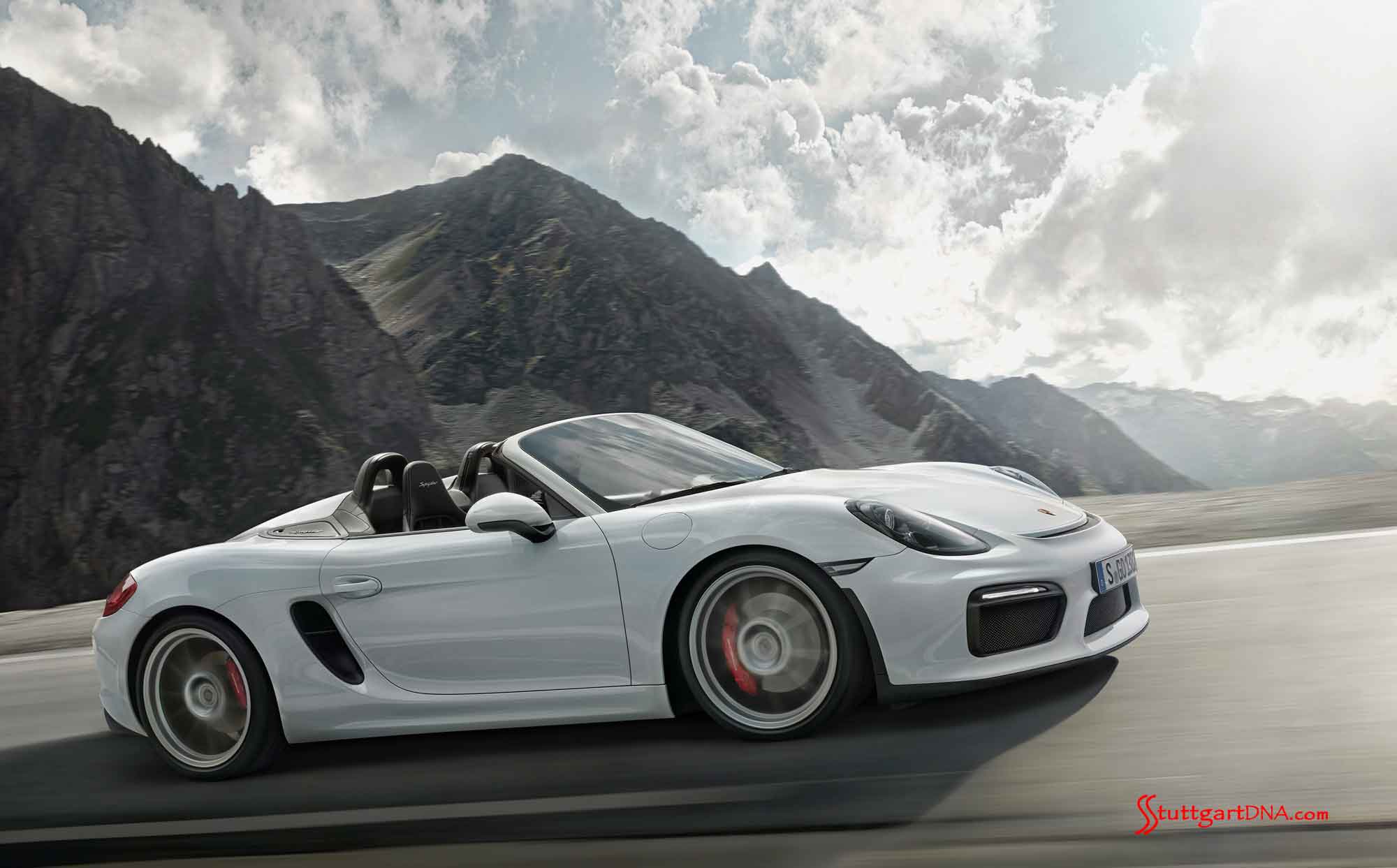 Boxster Spyder world premiere Boxster Spyder World Premiere: Boxster Spyder World Premiere: Seen from its passenger side, the white Boxster Spyder careens along a craggy-mountain road, its manually operated top down to partly cloudy skies. Credit: PCNA