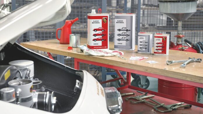 Porsche Classic Motoroil and 356 in garage. Credit: Porsche AG Pictured her is a display of Porsche Classic Motoroil in the background of a 356 in garage. Credit: Porsche AG